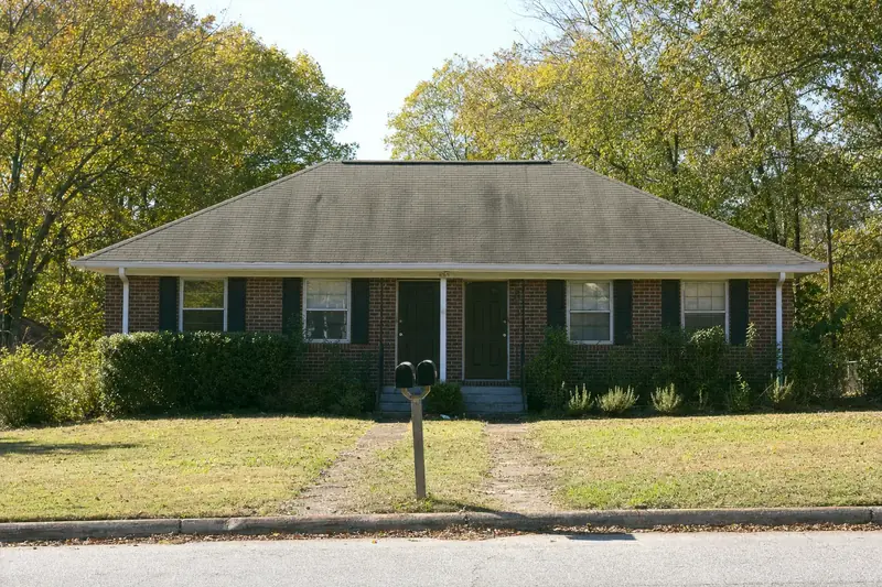 Brick duplex rental on a quiet street with a two-slot mailbox
